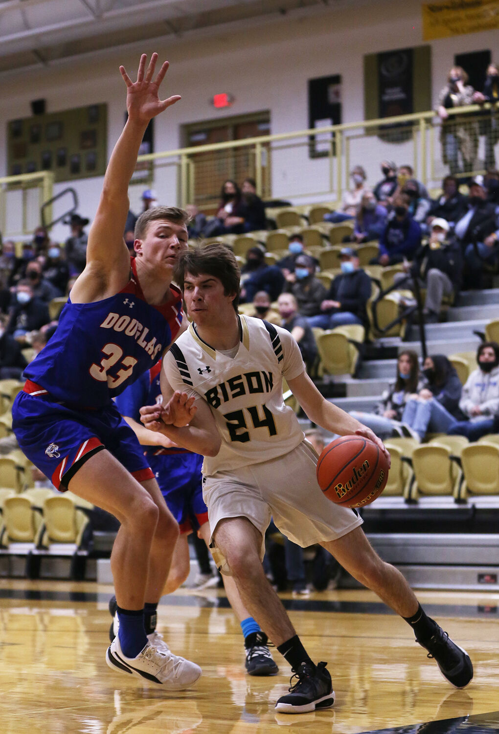 Colby Bessler dribbles under the basket through Douglas defender Garet Porter